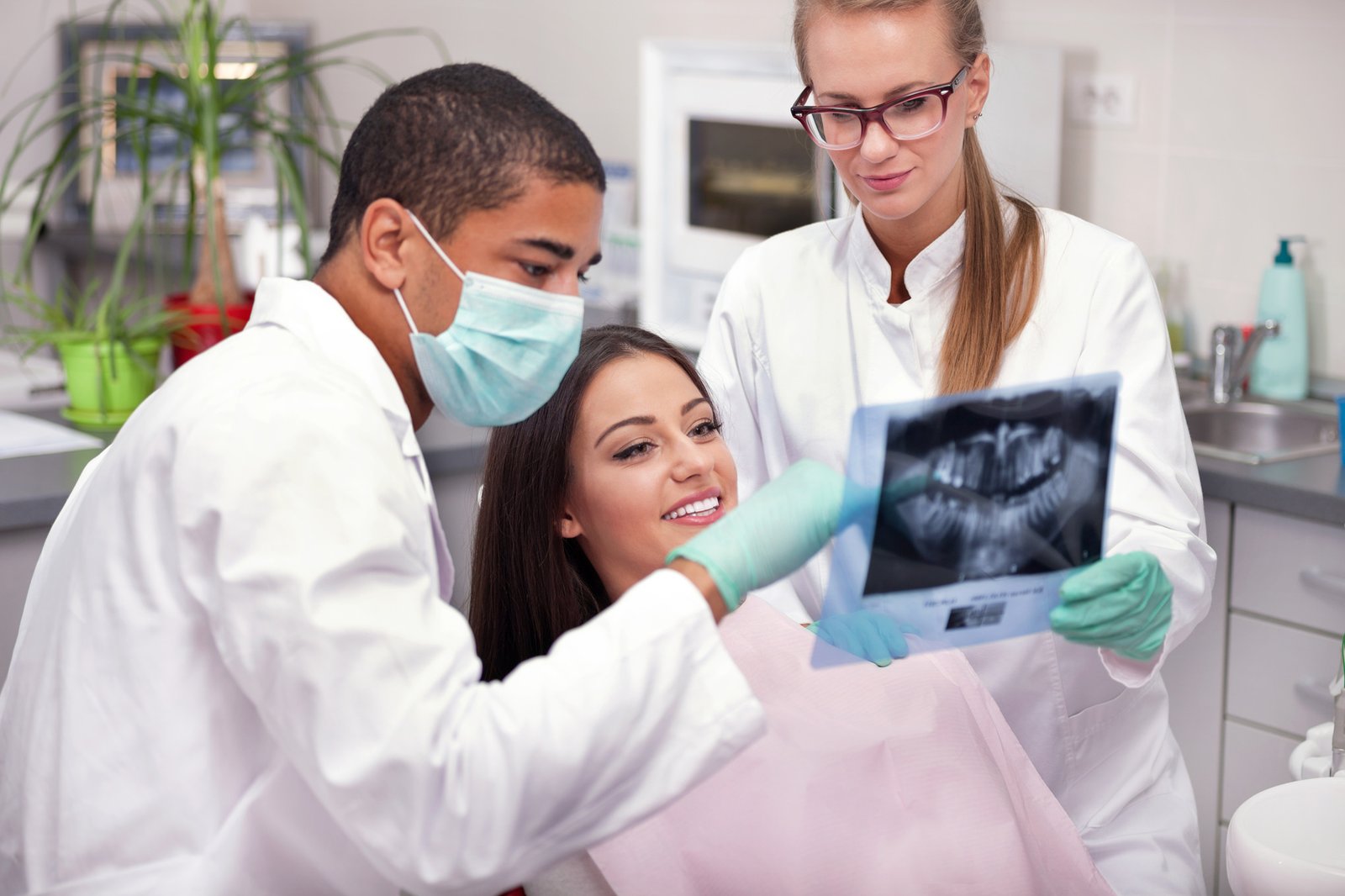 Dentist team and patient looking at x-ray image